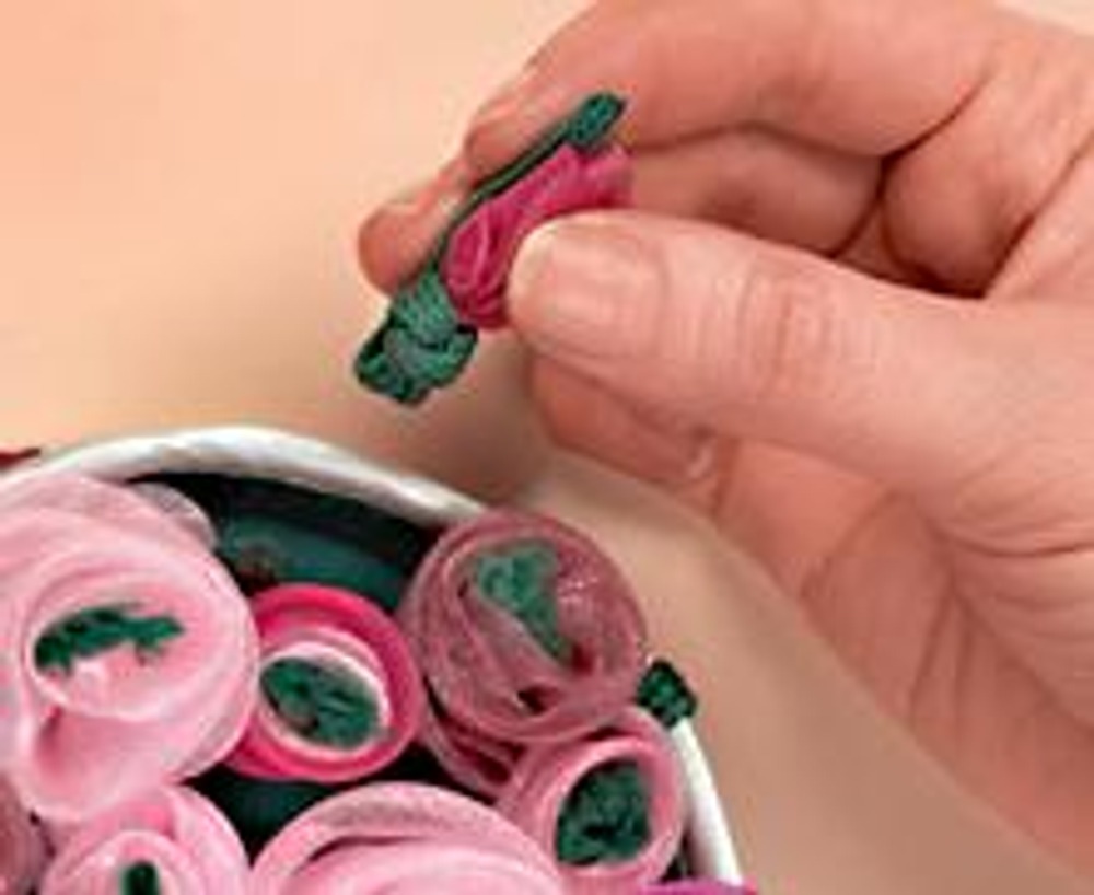 6. Сделайте цветы из органзы. Для стеблей нарежьте шнур на куски примерно по 7 см. Завяжите его узлом под каждым бутоном. Нашейте на крышку шкатулки.