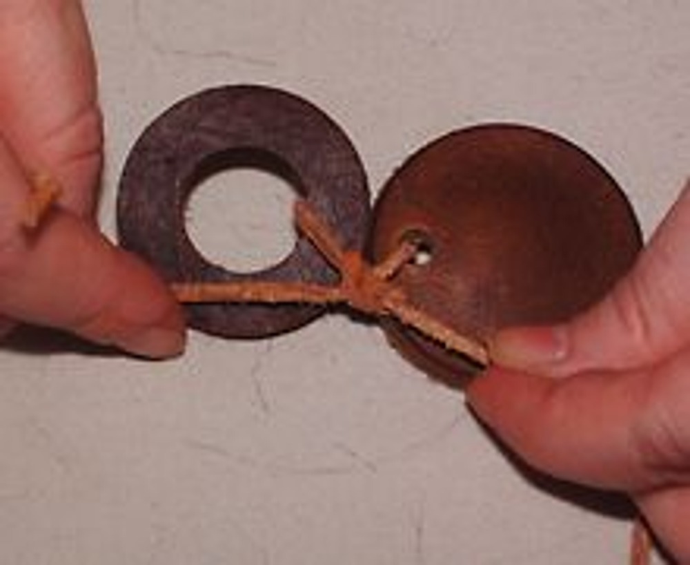2. С помощью кожаного шнура и обычных узелков соедините кружки различного диаметра между собой.